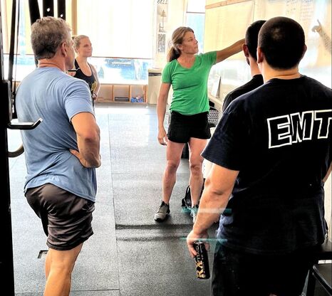 A coach talking a small group through a workout at CrossFit Unsung