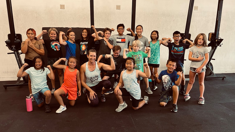 CrossFit Unsung kids and teens gathered in front of the rig after a class